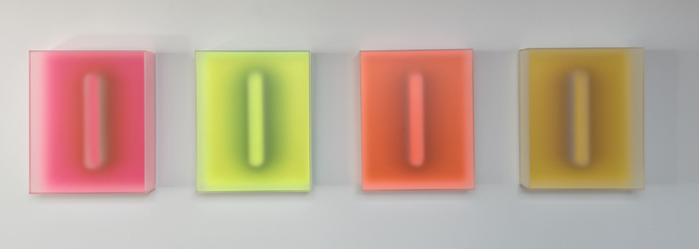 Four small wall-mounted Light Forms in pink, chartreuse, orange, and gold